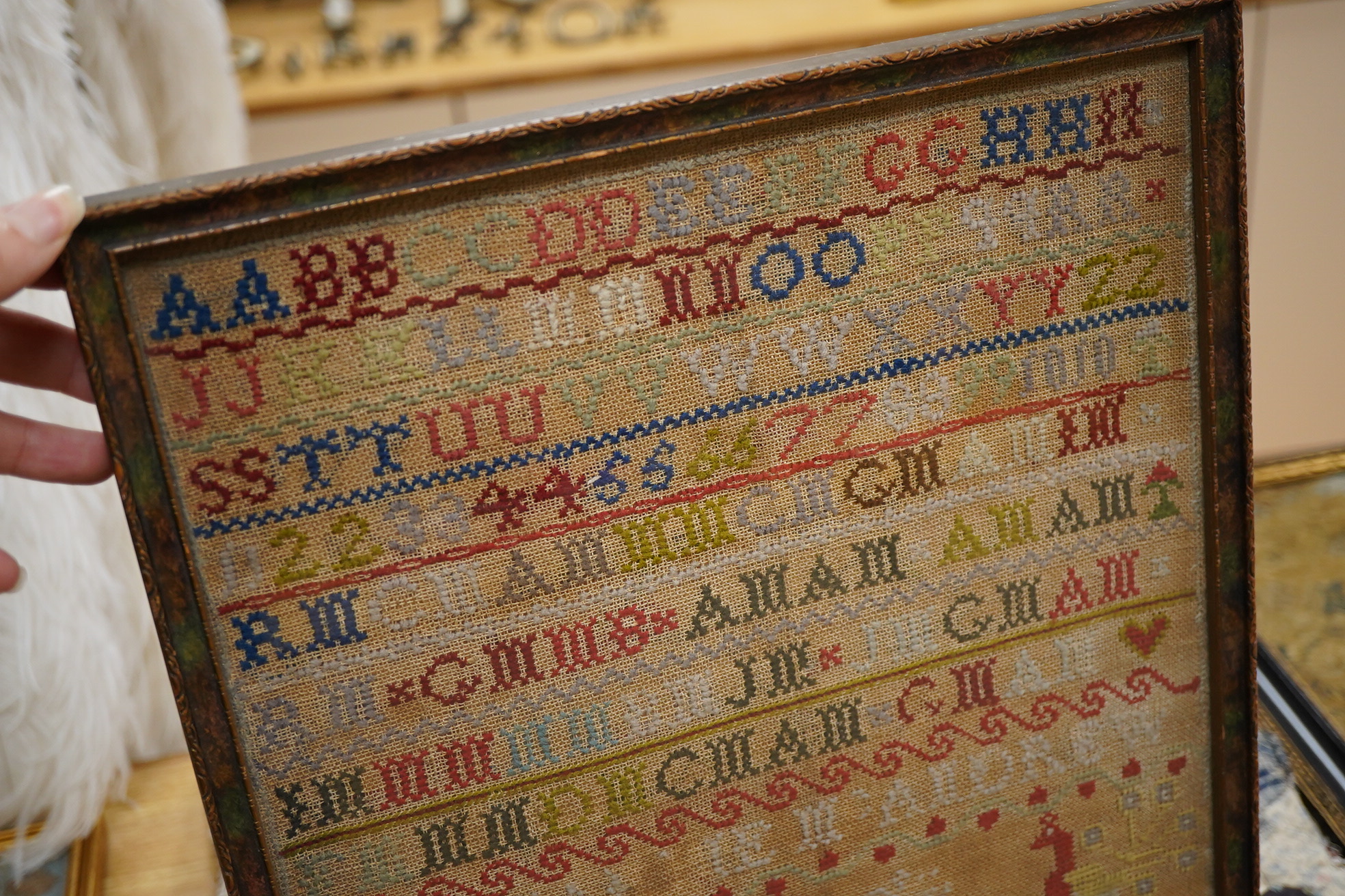 A 19th century alphabet cross stitch sampler, worked with a large house motif - 41cm x 29cm, together with a 19th century unfinished cotton patch worked central panel. Condition - the sampler has some stains but the thre